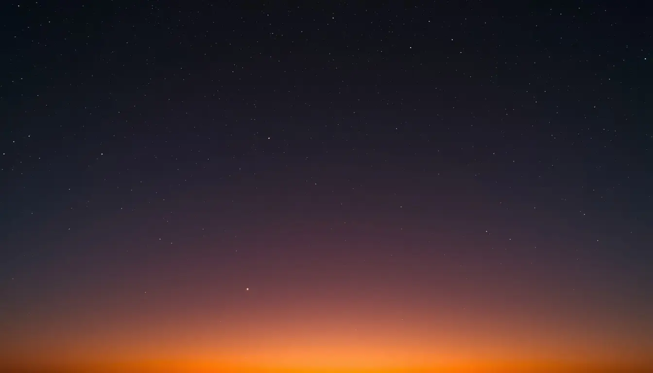 Twilight sky transitioning from a dark starry night to a glowing orange sunset horizon